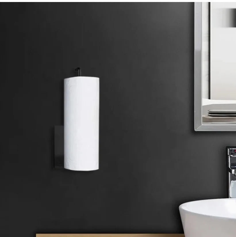 White cylindrical light fixture on a dark gray wall with a mirror and sink in the background.