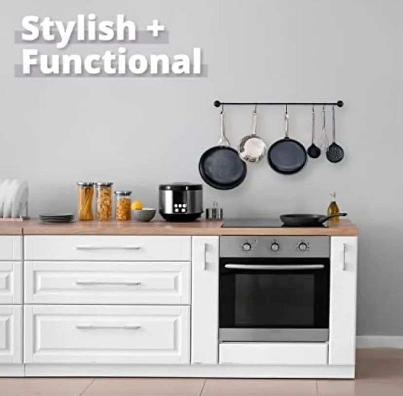 Modern kitchen setup with white cabinets, black appliances, and hanging pots.