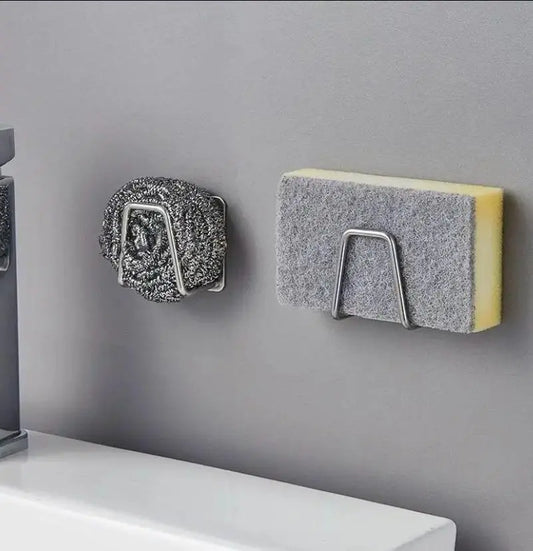Two scrubber holders with sponges attached to a gray wall.