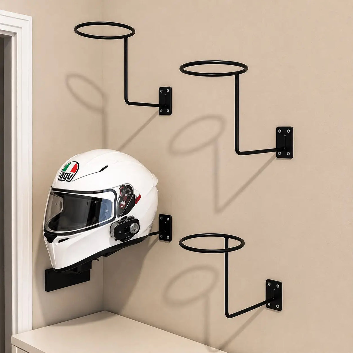 Black wall mounted metal motorcycle helmet holder with a white full face helmet