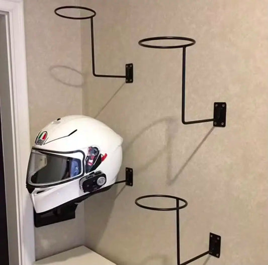 Black wall mounted metal motorcycle helmet holder with a white full face helmet